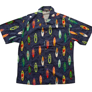May include: Navy blue short-sleeve button-down shirt with a colorful surfboard pattern. The surfboards are in various colors, including red, yellow, green, and white. The shirt has a classic collar and a relaxed fit.