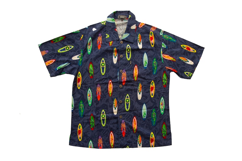 May include: Navy blue short-sleeve button-down shirt with a colorful surfboard pattern. The surfboards are in various colors, including red, yellow, green, and white. The shirt has a classic collar and a relaxed fit.