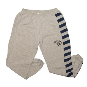 May include: Light grey sweatpants featuring a dark blue striped panel running down the outer side of the right leg. The text IBM PS1 is printed in dark grey on the right thigh area. These sweatpants have an elastic waistband and cuffed ankles.