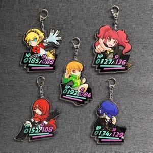 May include: Five acrylic keyrings featuring anime-style characters. Each keyring has a different character in various poses, with a silver keyring attached. The keyrings have a black base with HP and SP stats.