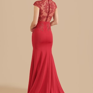 Pode incluir: Um vestido vermelho longo at&eacute; o ch&atilde;o com um corpete justo e uma saia fluida. O corpete apresenta uma sobreposi&ccedil;&atilde;o de renda transparente com bordados florais e um decote alto. A parte de tr&aacute;s do vestido tem uma fila de bot&otilde;es.