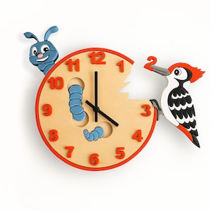 May include: A novelty wooden wall clock with a light brown face, red numerals, and a red border. A blue caterpillar and a woodpecker are attached. The woodpecker is black, white, and red, adding a playful touch.