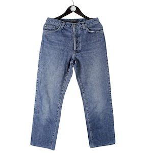 May include: A pair of blue denim jeans with a straight leg fit. The jeans have a classic five-pocket style and a button fly.