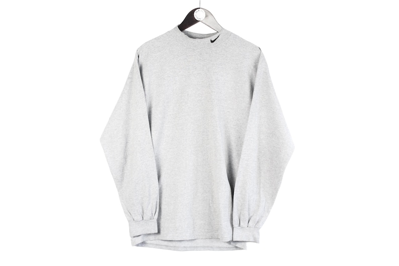 May include: A gray long-sleeve shirt with a black Nike swoosh logo on the front.