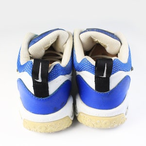 Może przedstawiać: Para białych i niebieskich but&oacute;w sportowych z czarnymi akcentami. Buty mają siateczkową cholewkę i gumową podeszwę.