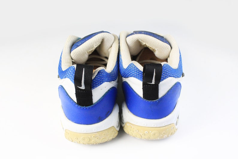 Może przedstawiać: Para białych i niebieskich but&oacute;w sportowych z czarnymi akcentami. Buty mają siateczkową cholewkę i gumową podeszwę.