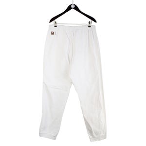 May include: White sweatpants with a drawstring waist and a cuffed hem.