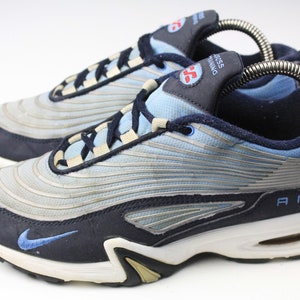 May include: A pair of blue and silver Nike Air Cross Training sneakers with white soles. The shoes have a blue swoosh logo on the side and the word "AIR" on the back.