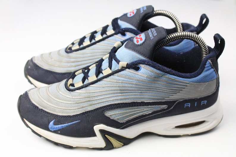 May include: A pair of blue and silver Nike Air Cross Training sneakers with white soles. The shoes have a blue swoosh logo on the side and the word "AIR" on the back.