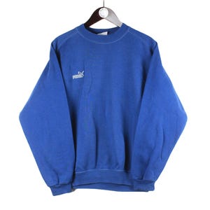 May include: A blue sweatshirt with a white Puma logo on the left chest.