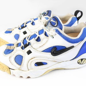 Może przedstawiać: Białe i niebieskie buty sportowe z czarnymi akcentami i napisem "AIR" na podeszwie.