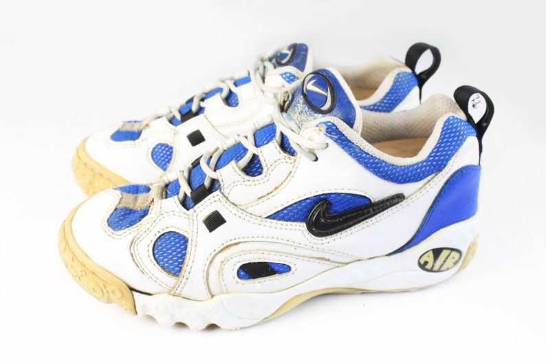 Może przedstawiać: Białe i niebieskie buty sportowe z czarnymi akcentami i napisem "AIR" na podeszwie.