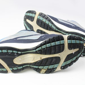 May include: A pair of blue and white athletic shoes with black soles. The shoes have a textured tread pattern and are designed for running or walking.
