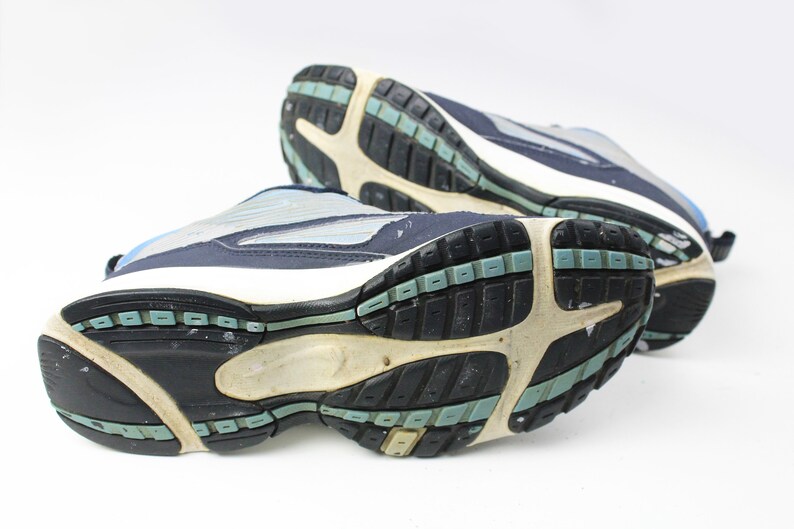 May include: A pair of blue and white athletic shoes with black soles. The shoes have a textured tread pattern and are designed for running or walking.