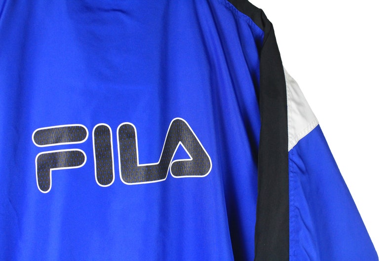 May include: Blue, black, and white windbreaker jacket with the word "FILA" in black and white on the back.