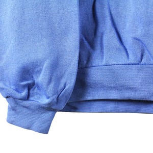 May include: A blue sweatshirt with a ribbed cuff. The sweatshirt is made of a soft, comfortable fabric.