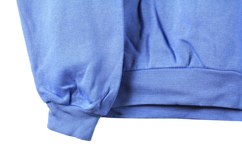 May include: A blue sweatshirt with a ribbed cuff. The sweatshirt is made of a soft, comfortable fabric.