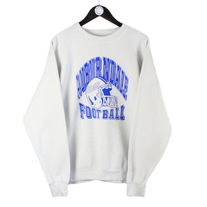 May include: White sweatshirt with a blue graphic of a football helmet and the text "North Randall Football".