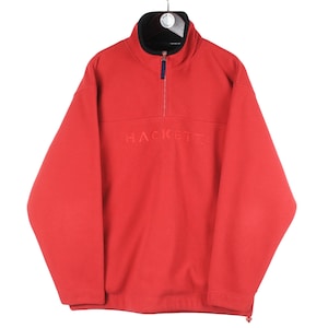 Puede incluir: Sudadera de forro polar roja con cierre de cremallera de media cremallera y la palabra "HACKETT" bordada en la parte delantera.