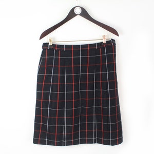 May include: A black and white plaid skirt with red accents. The skirt has a straight silhouette and a mid-length hemline.