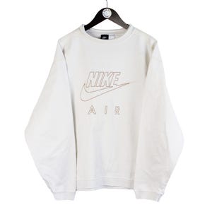 May include: White long-sleeve sweatshirt with a red and white Nike Air logo.