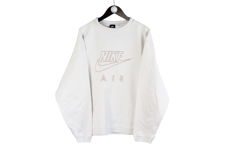 May include: White long-sleeve sweatshirt with a red and white Nike Air logo.