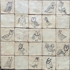 May include: A collection of twenty-five square ceramic tiles. Each tile features a unique black ink illustration of an owl. The owls are depicted in various poses and styles, set against a cream-colored background.