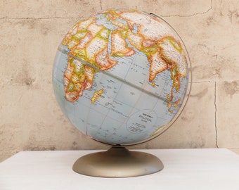 May include: A vintage blue and yellow globe with a metal stand. The globe is labeled "New World Political Globe".
