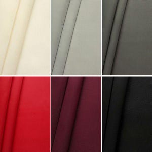 Könnte beinhalten: Eine Sammlung von Stoffmustern in verschiedenen Farben, darunter Beige, Grau, Rot, Burgunderrot und Schwarz. Der Stoff ist glatt und hat einen dezenten Glanz.