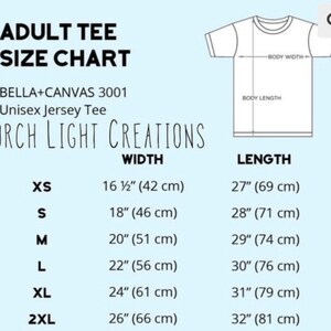 May include: Adult tee size chart with measurements in inches and centimeters. Includes sizes XS to 2XL, with width ranging from 16 1/2" (42 cm) to 26" (66 cm) and length from 27" (69 cm) to 32" (81 cm). The chart also shows a diagram of a t-shirt.
