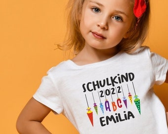 weißes Kinder T-Shirt "Schulkind" mit ABC-Motiv I personalisiert mit Namen - Geschenk zur Einschulung für Jungen & Mädchen