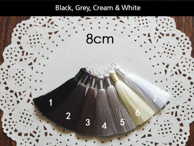 May include: Seven tassel trims in black, dark gray, light gray, cream, and white. The tassels are 8 cm long.