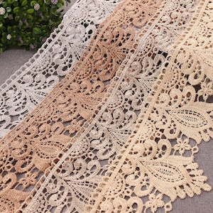 Puede incluir: Tres anchos diferentes de encaje beige con un delicado patrón floral. El encaje está hecho de un material suave y ligero y tiene un borde festoneado.