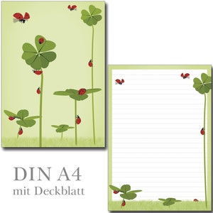 Könnte beinhalten: Briefpapier-Set mit einem verspielten Design aus vierblättrigen Kleeblättern und roten Marienkäfern auf hellgrünem Hintergrund. Enthält einen linierten Notizblock und eine größere Illustration.