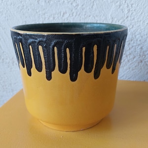 Könnte beinhalten: Ein Set aus drei Keramikbechern mit gesprenkelter, matter Oberfläche. Die Becher sind in Creme-, Hellgrau- und Dunkelgrautönen gehalten. Jeder Becher hat ein schlichtes, minimalistisches Design.