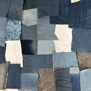 Könnte beinhalten: Ein Patchwork aus Denim-Stoffstücken in verschiedenen Blautönen, von hell bis dunkel, und einigen weißen Stoffstücken. Die Anordnung erzeugt ein strukturiertes, geometrisches Muster, das sich für Bastel- oder Designprojekte eignet.