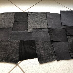 Könnte beinhalten: Ein Patchwork-Deckenstück aus verschiedenen grauen und schwarzen Stoffquadraten. Die Decke besteht aus verschiedenen Texturen und Materialien.