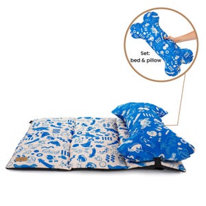 May include: A blue and white patterned dog bed and pillow set. The pillow is shaped like a bone and the bed is folded in half. The text "Set: bed & pillow" is visible in the image.