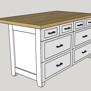 May include: White kitchen island with a wood countertop and eight drawers. The drawers have black pulls.