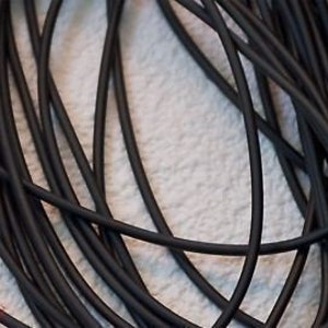 Könnte beinhalten: Nahaufnahme eines Bündels schwarzen Gummibands. Das Band ist glatt und flexibel und eignet sich ideal für Bastelarbeiten.