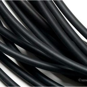 May include: A close-up of a bundle of black rubber tubing. The tubing is flexible and has a smooth surface.