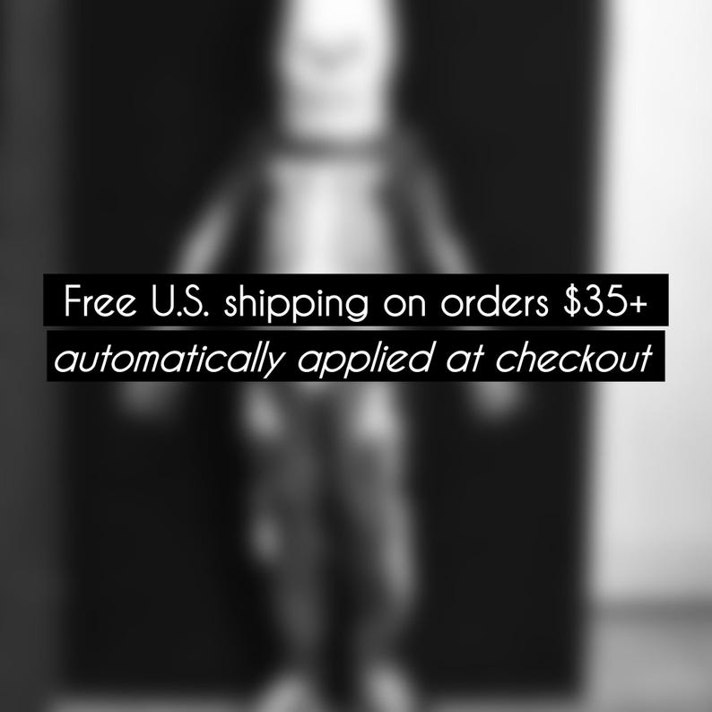 Peut inclure: Image en noir et blanc avec le texte "Free U.S. shipping on orders $35+ automatically applied at checkout". Une silhouette floue est au centre, sur fond sombre.