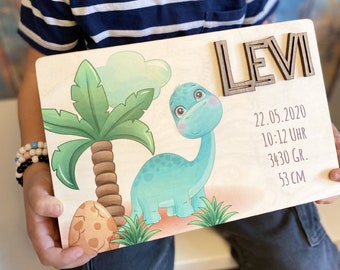 May include: A wooden sign with a blue dinosaur and a palm tree. The sign says "Levi" and includes the date "22.05.2020", time "10:12 Uhr", weight "3430 Gr.", and length "53 CM".