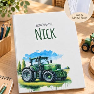Op de afbeelding: Een witte map met de tekst "MEINE ZEUGNISSE" en "NICK" in donkergroen. De kaft toont een aquarelillustratie van een groene tractor in een veld onder een blauwe lucht. Een cirkelvormig inzetstuk toont vijf doorzichtige A4-insteekhoezen.