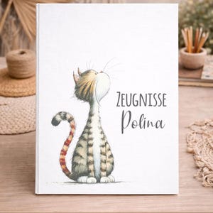 Peut inclure: Un cahier blanc avec une illustration d'un chat regardant vers le haut. Le chat est rayé de marron et de gris, avec une queue rayée rouge et marron. Le texte "ZEUGNISSE Polina" est inscrit sur la couverture.