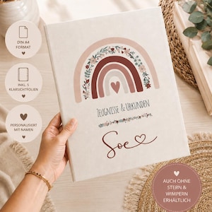 Può includere: Una cartella portadocumenti A4 bianca con un design stampato di un arcobaleno con accenti floreali e un cuore centrale. Il testo riporta Zeugnisse & Urkunden e il nome Soe. Include cinque buste di plastica trasparente per conservare documenti.