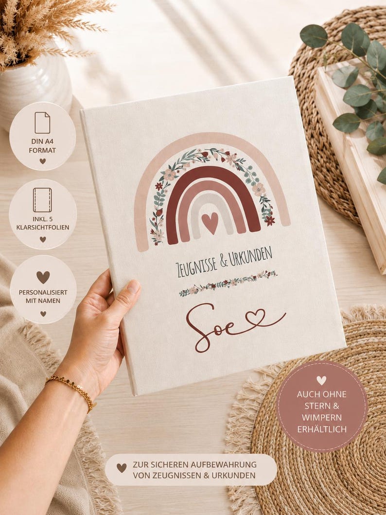 May include: A white A4 document folder featuring a printed design of a rainbow with floral accents and a central heart. The text reads Zeugnisse & Urkunden and the name Soe. It includes five clear plastic sleeves for document storage and protection.