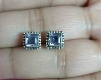 May include: A pair of silver earrings with square-shaped amethyst gemstones.