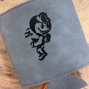 May include: Gray leather can cooler with a black and white cartoon mascot wearing a hat. The mascot is running and has a happy expression.