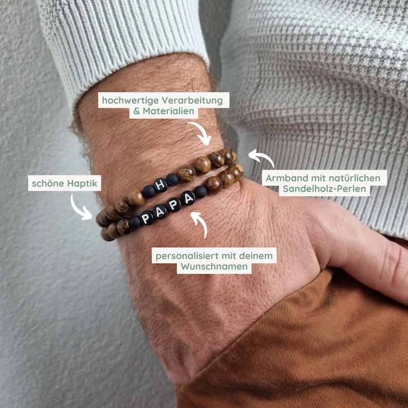 May include: A brown wooden bracelet with black beads that spell out "PAPA" and "H". The bracelet is on a person's wrist. The text "hochwertige Verarbeitung & Materialien", "sch&ouml;ne Haptik", "personalisiert mit deinem Wunschnamen", and "Armband mit nat&uuml;rlichen Sandelholz-Perlen" is written around the bracelet.